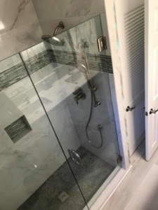 A newly installed glass shower enclosure with modern fixtures and tile work by Brown Remodeling And New Construction in Hoover, AL.