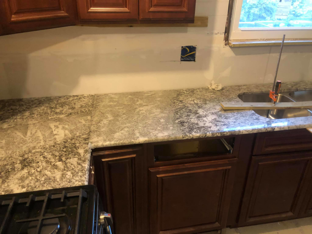 A section of a newly installed granite countertop in a kitchen under renovation by Fine Design Marble And Granite in Springfield, MA.