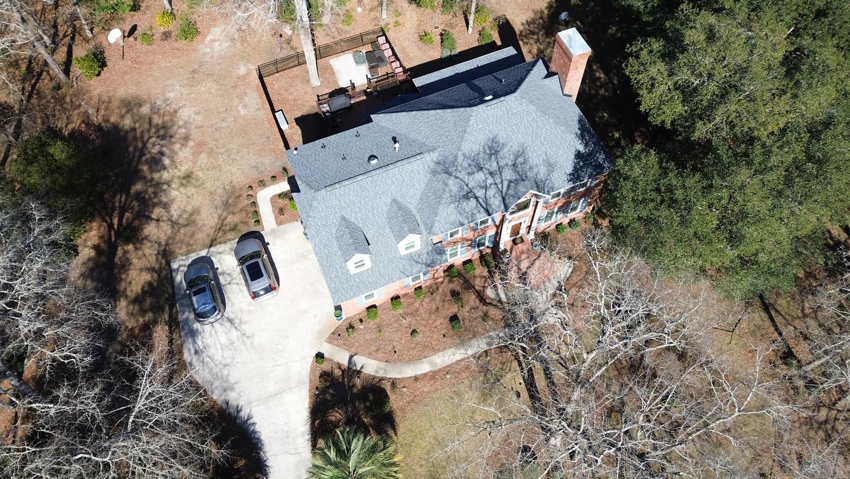 An aerial view of a large house with a newly installed gray shingle roof by Coastal Roofing Solutions LLC in Charleston, SC.