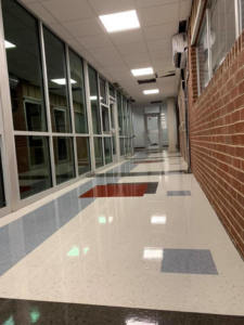 Newly installed, multi-colored tile flooring in a long hallway, a service provided by Aggregate in Enid, OK