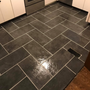 A newly installed dark tiled floor in a herringbone pattern by Ken Sweeney Property Solutions in Knoxville, TN