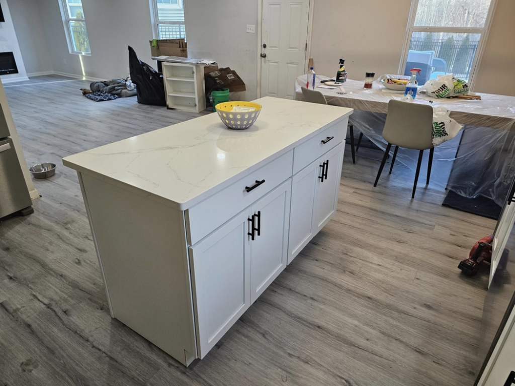 A newly installed white kitchen island with a quartz countertop, part of a kitchen renovation by All Trades Home Improvement in Hobart, IN.
