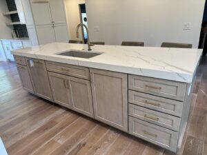 A newly installed kitchen island with a modern sink and light-colored cabinetry, completed by Legacy Builders Group in Cincinnati, OH.