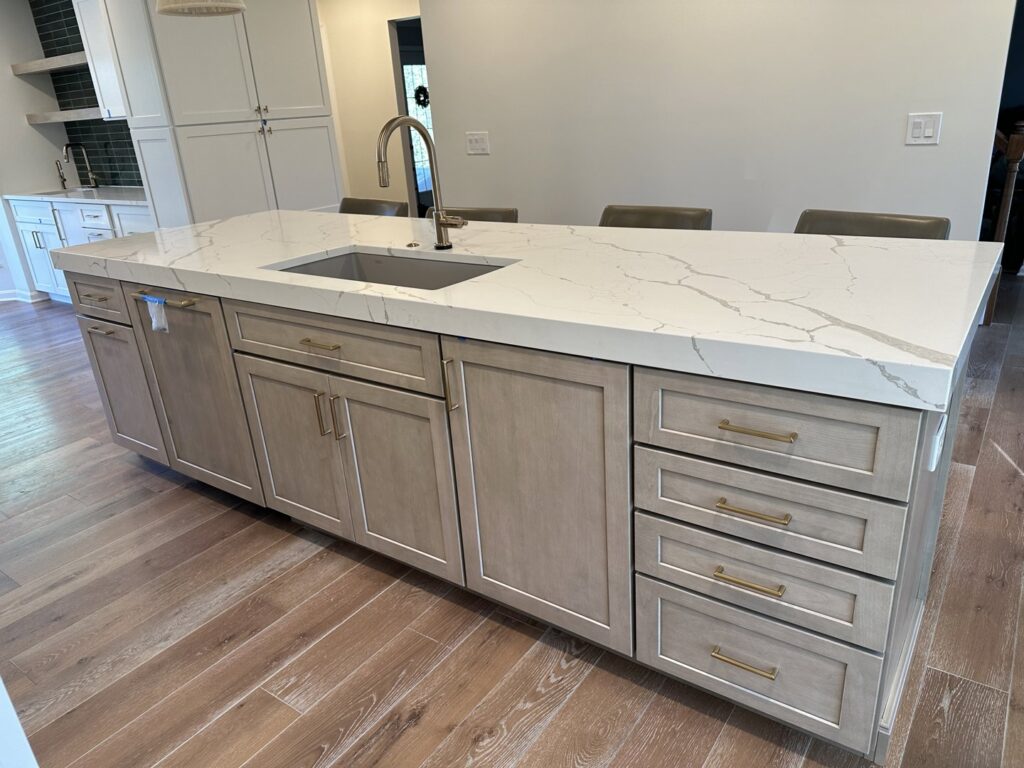 A newly installed kitchen island with a modern sink and light-colored cabinetry, completed by Legacy Builders Group in Cincinnati, OH.