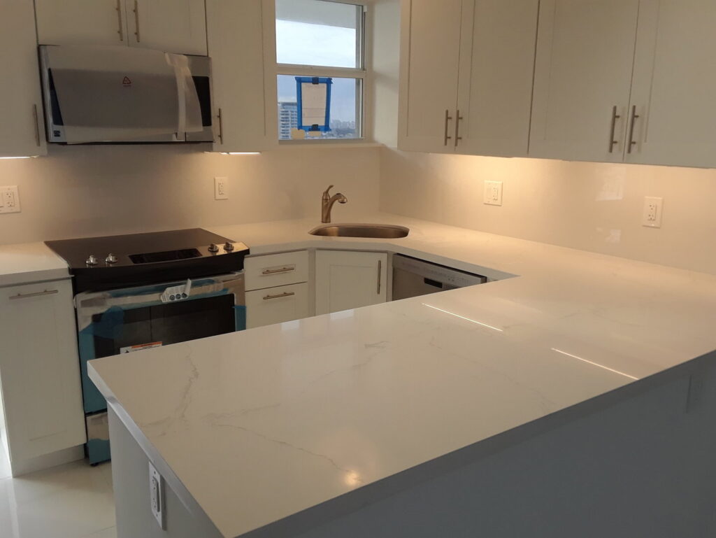 A newly installed kitchen with white cabinets and light countertops by Corley Construction Inc in Fort Lauderdale, FL