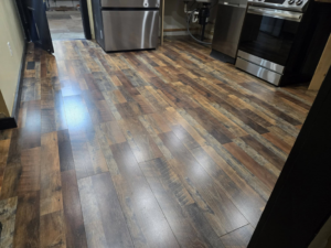 Newly installed laminate flooring in a kitchen by Sure Can LLC Handyman Services in South Charleston, WV.