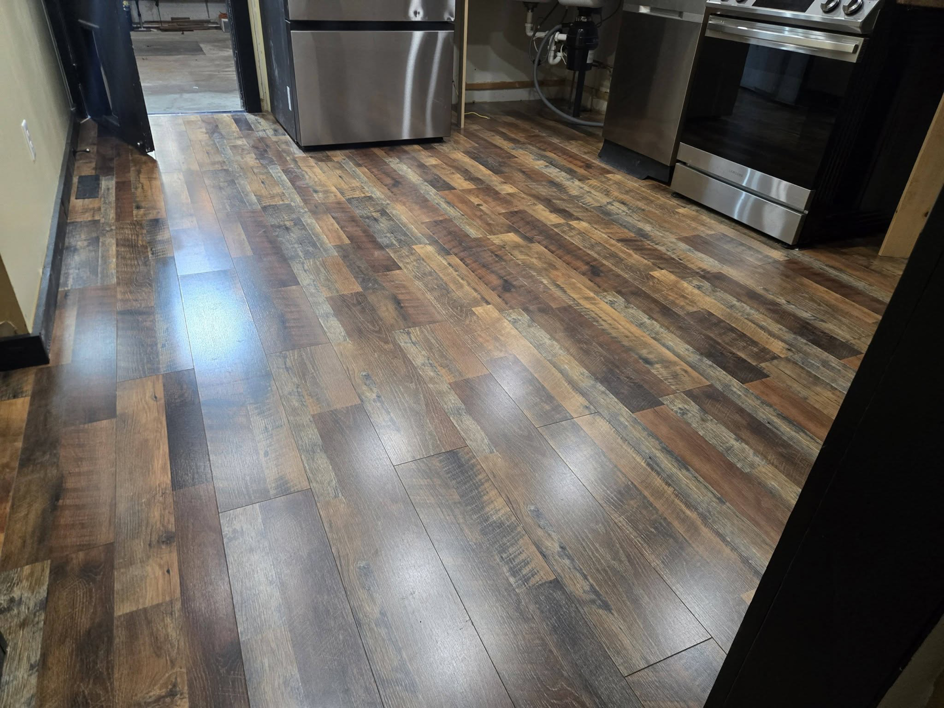 Newly installed laminate flooring in a kitchen by Sure Can LLC Handyman Services in South Charleston, WV.