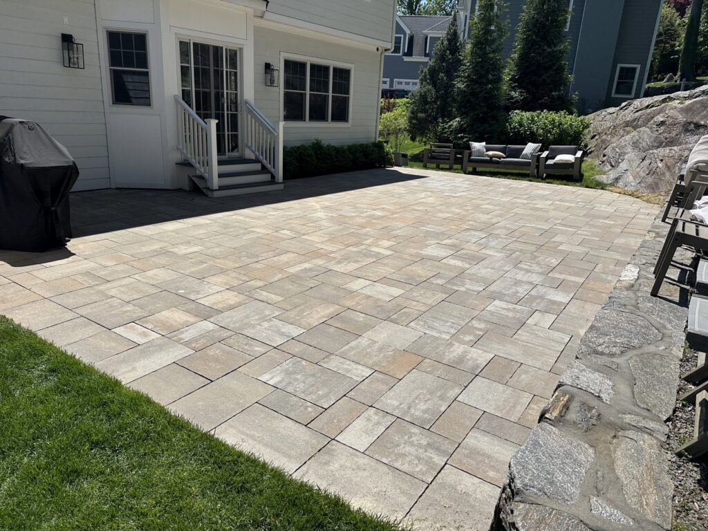 A newly installed paver patio and stone retaining wall by Cappco Pressure Washing in New Rochelle, NY