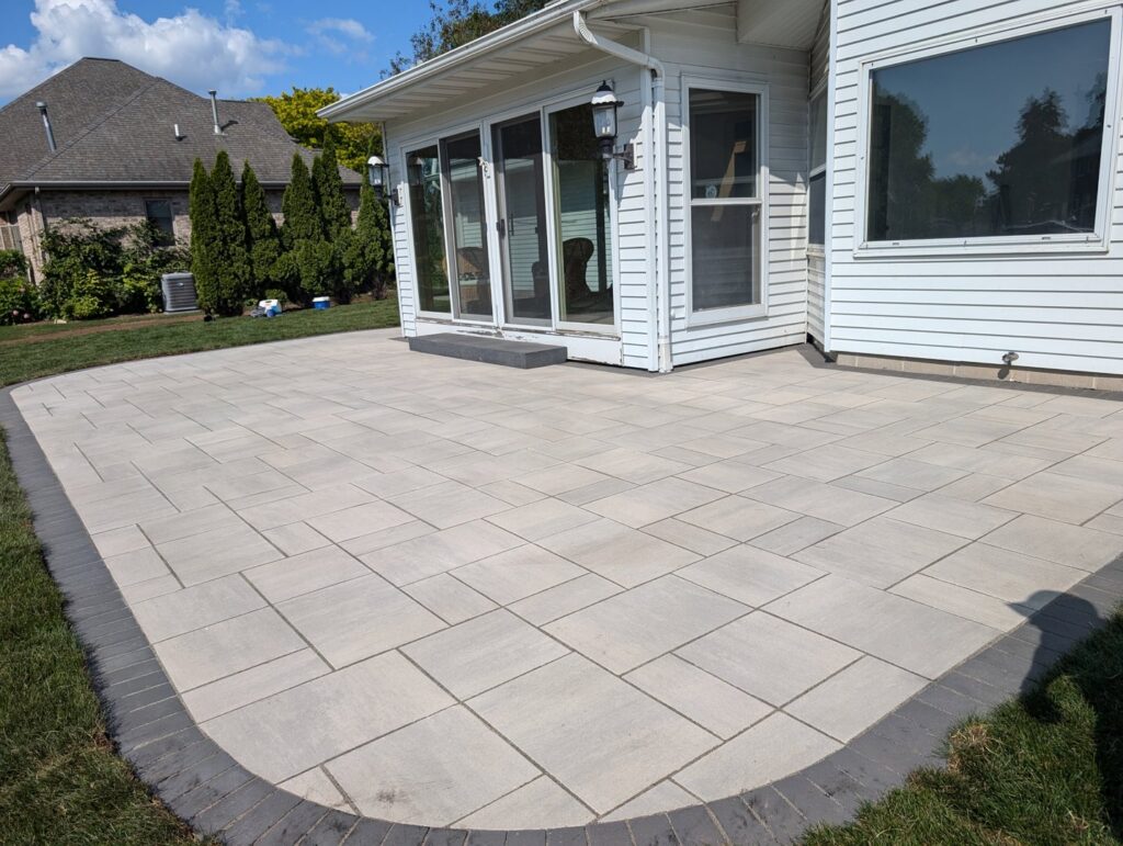 A newly installed paver patio next to a residential home by Wildflower Landscapers LLC in Larsen, WI