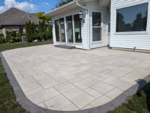 A newly installed paver patio next to a residential home by Wildflower Landscapers LLC in Larsen, WI