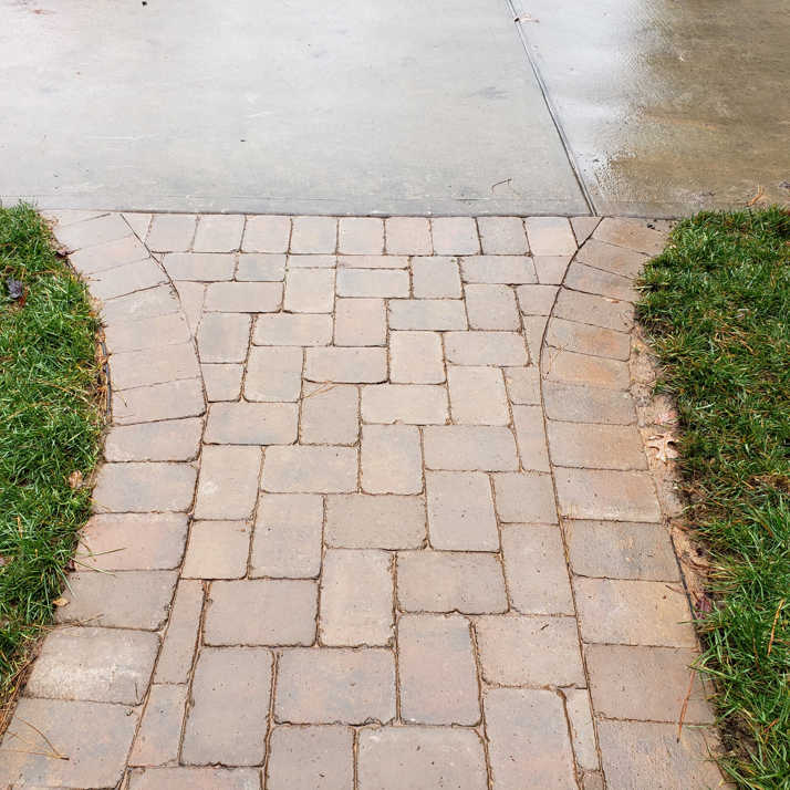 Close-up of a newly installed paver walkway connecting concrete to grass by Raleigh Deck & Screen Porch Builder in Raleigh, NC