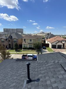 A newly installed residential roof by Riker Home Services, with a view of the Plano, TX neighborhood