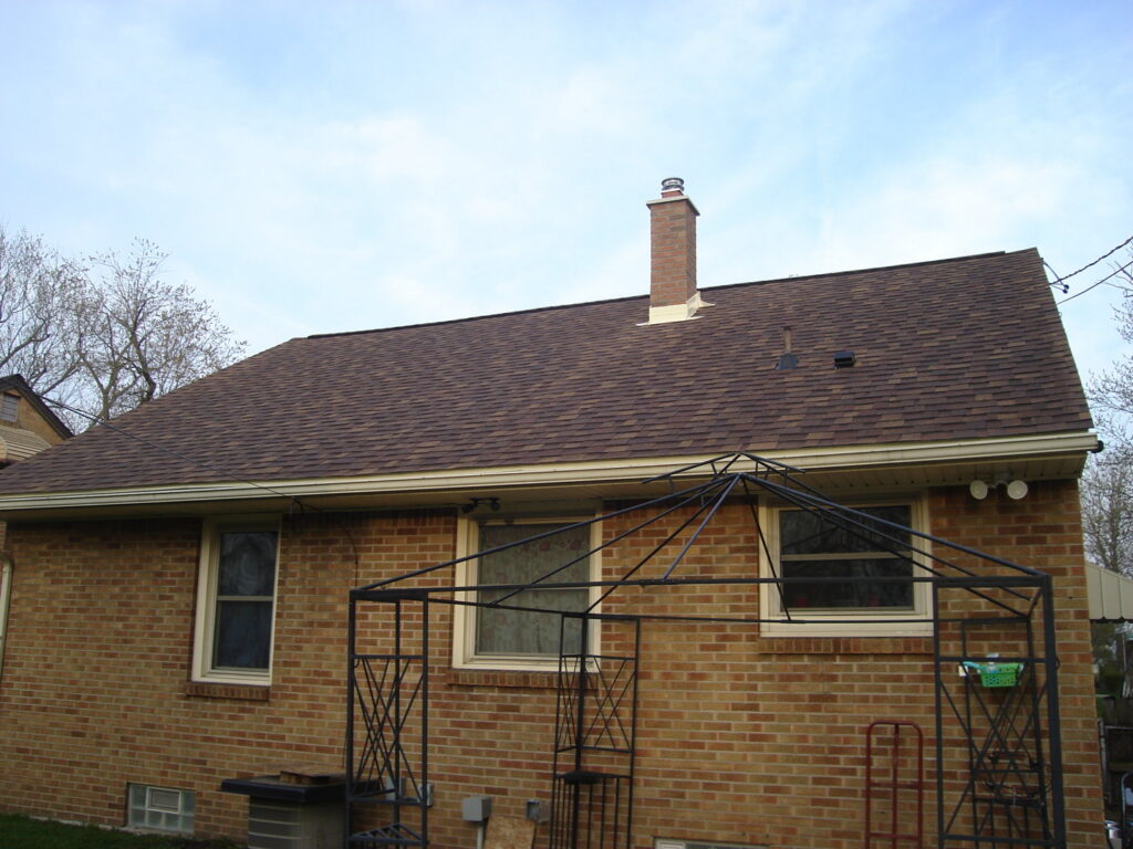 A residential house with a newly installed brown shingle roof, completed by Done Well Home Improvement LLC in Buffalo, NY.