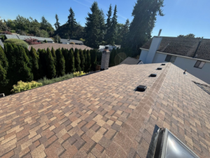A newly installed shingle roof with vents and a skylight, completed by Full Throttle Remodel in Salem, OR.
