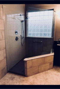 A newly installed walk-in shower with glass walls and a tiled half-wall by Juan The Handyman LLC in Kansas City, KS