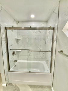 A newly installed shower with modern glass sliding doors and tiled walls by Cutting Edge Carpentry & Construction in Lawton, OK.