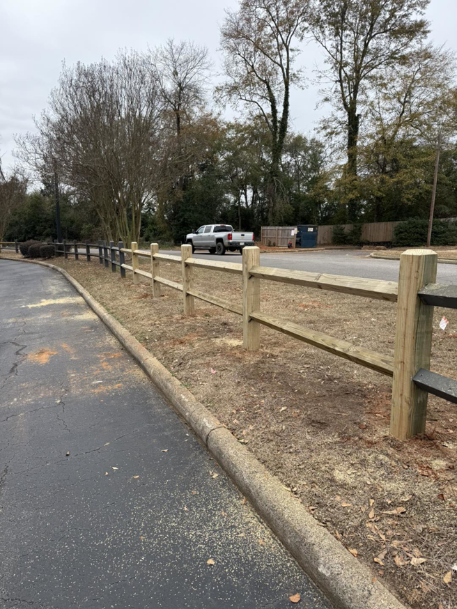 A newly installed wooden split-rail fence by Legacy Fence, LLC in Aiken, SC, showing fresh sawdust from the installation.
