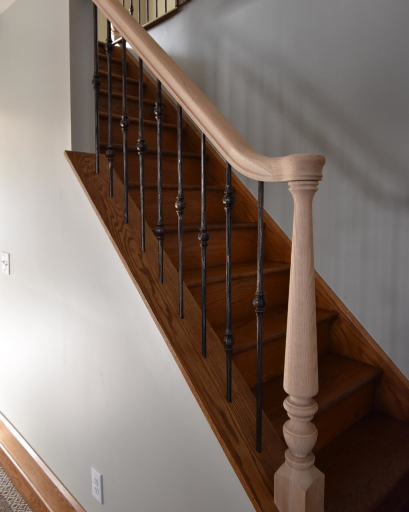 A newly installed wooden staircase with elegant metal balusters by R4R General Contracting in Columbus, OH.