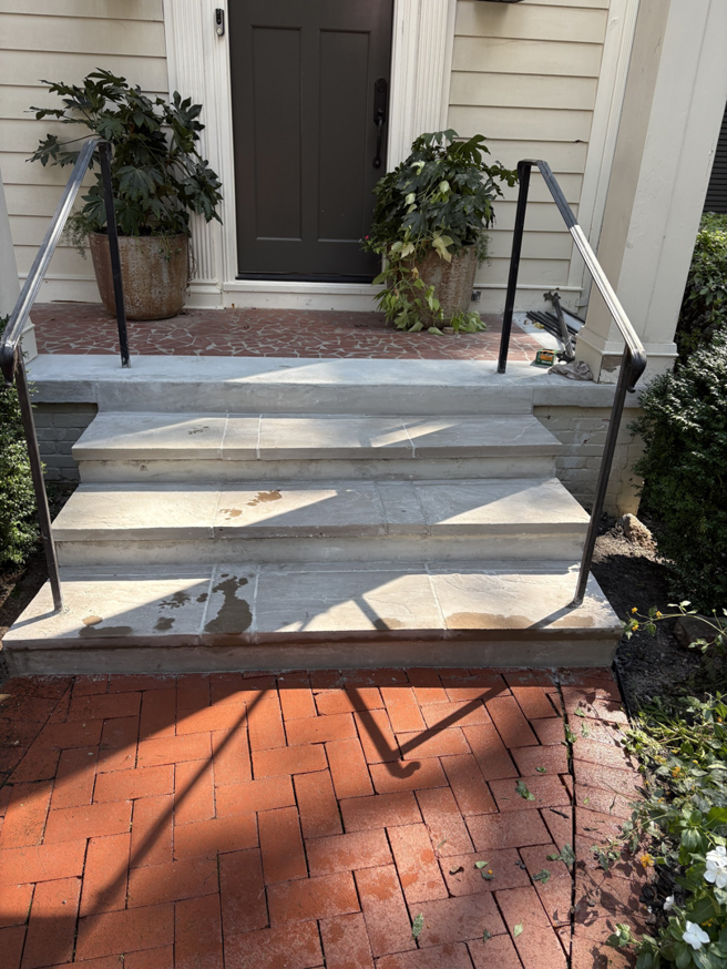 Newly installed stone steps with sturdy metal handrails by Easier Remodeling LLC in Sandy Springs, GA.