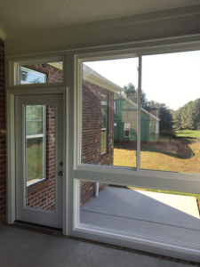 A newly installed sunroom with large windows and a door, showcasing home improvement work by Gerald Jones Company in Durham, NC.