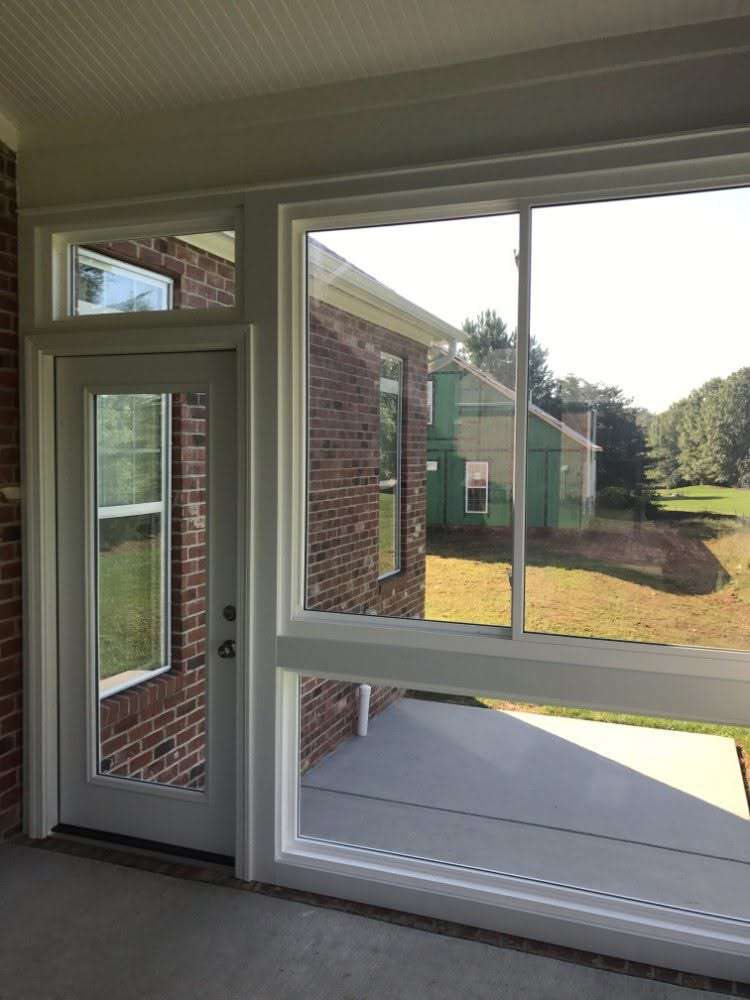 A newly installed sunroom with large windows and a door, showcasing home improvement work by Gerald Jones Company in Durham, NC.