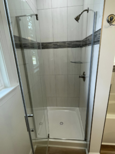 A newly installed walk-in shower with clear glass doors and modern tiled walls by Govco Builders, Inc. in Newport News, VA