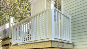A newly installed white deck railing on a wooden deck, completed by Sini's Handyman Services in Falmouth, ME.