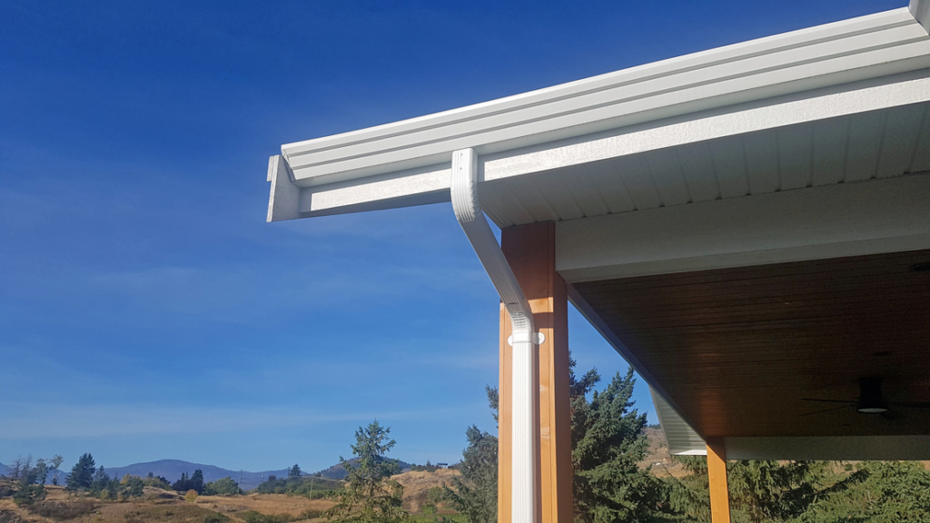 Newly installed white gutters and soffit on a house exterior, a service by Coburns interior and exterior in Services Available In.