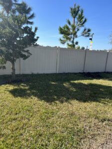 A newly installed white vinyl fence in a residential backyard, a service completed by Lula - Reinventing Property Maintenance in Overland Park, KS.