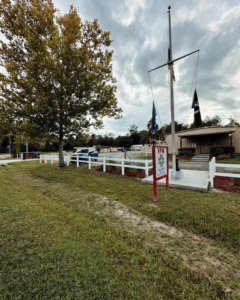 A newly installed white vinyl fence surrounding a VFW post, completed by LV Fence and Gates in Jacksonville, FL.