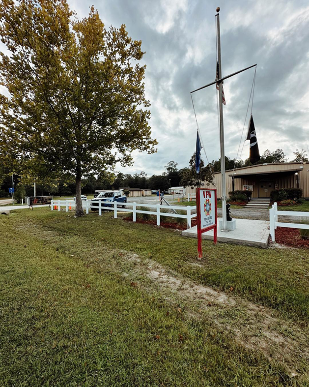 A newly installed white vinyl fence surrounding a VFW post, completed by LV Fence and Gates in Jacksonville, FL.