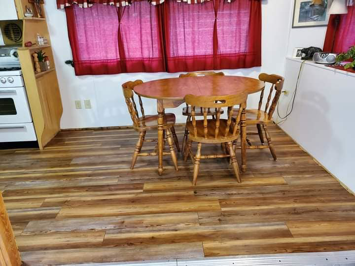 Beautiful newly installed wood-look flooring in a dining area by Handyman Heroes, serving Roswell, NM.