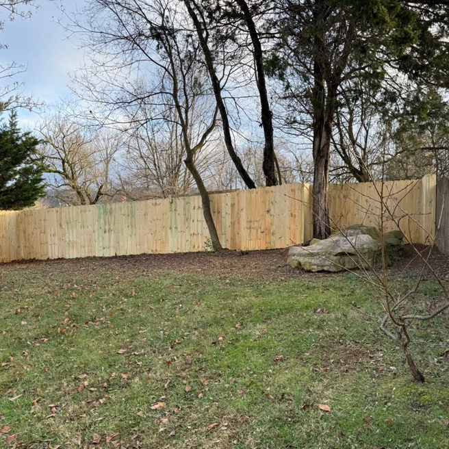 A newly installed wooden privacy fence in a residential backyard by Tim's Fencing in Knoxville, TN.