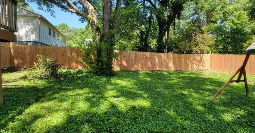 A newly installed wood privacy fence enclosing a green backyard, completed by Dogwood Renovation & Design, LLC in Kansas City, MO.
