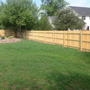 A newly installed wood privacy fence in a residential backyard by Woodsmith Fence Corp in Lockport, NY.