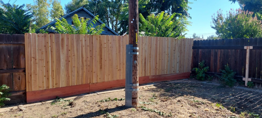 A newly installed wooden backyard fence, demonstrating quality craftsmanship by Montano's Handyman in Fresno, CA