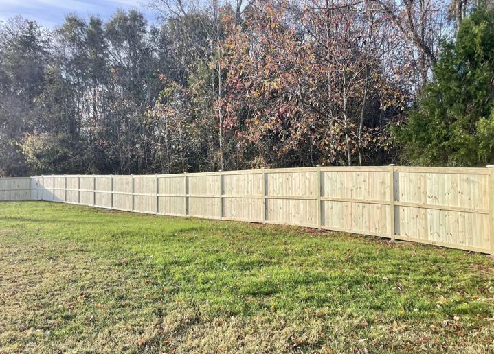 A newly installed wooden privacy fence in a backyard, built by RJS Custom Decks in Cibolo, TX.