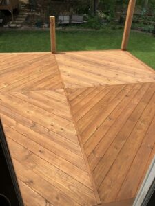 A close-up view of a newly installed wooden deck with a diagonal pattern by HandyVets in Saint Charles, MO.