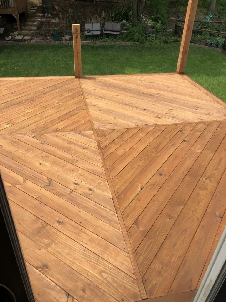 A close-up view of a newly installed wooden deck with a diagonal pattern by HandyVets in Saint Charles, MO.