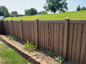 A newly installed brown wooden fence with decorative post caps, a handyman service by ACE Roofing & Construction in Ruskin, FL