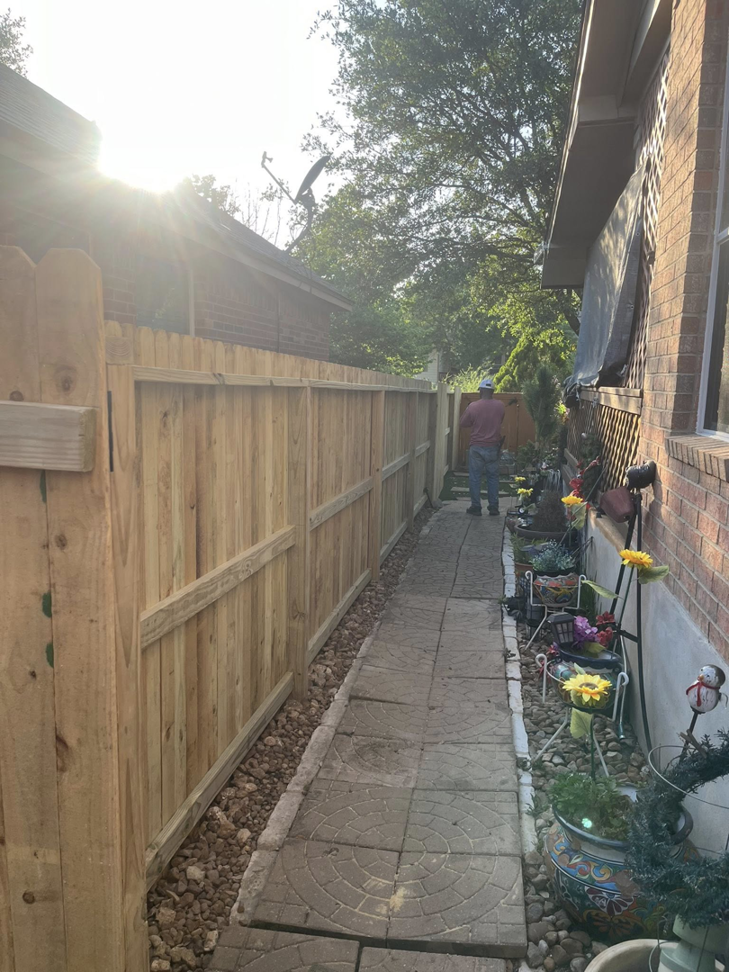 A newly installed wooden fence along a residential property, showcasing general contractor work by Triple A' Construction in San Antonio, TX.