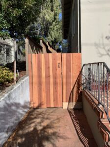 A newly installed wooden gate securing a narrow side yard, a project by Dan's Home and Yard in Oakland, CA.