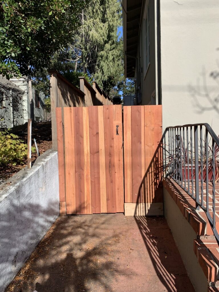 A newly installed wooden gate securing a narrow side yard, a project by Dan's Home and Yard in Oakland, CA.