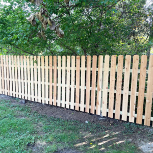 A newly installed wooden picket fence providing privacy and security by Cutting Edge Contracting and Handyman in Minneapolis, MN.