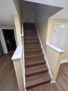 Newly installed wooden staircase with white trim by Steve Way Builders, LLC - The Remodeling Specialist in Lansing, MI