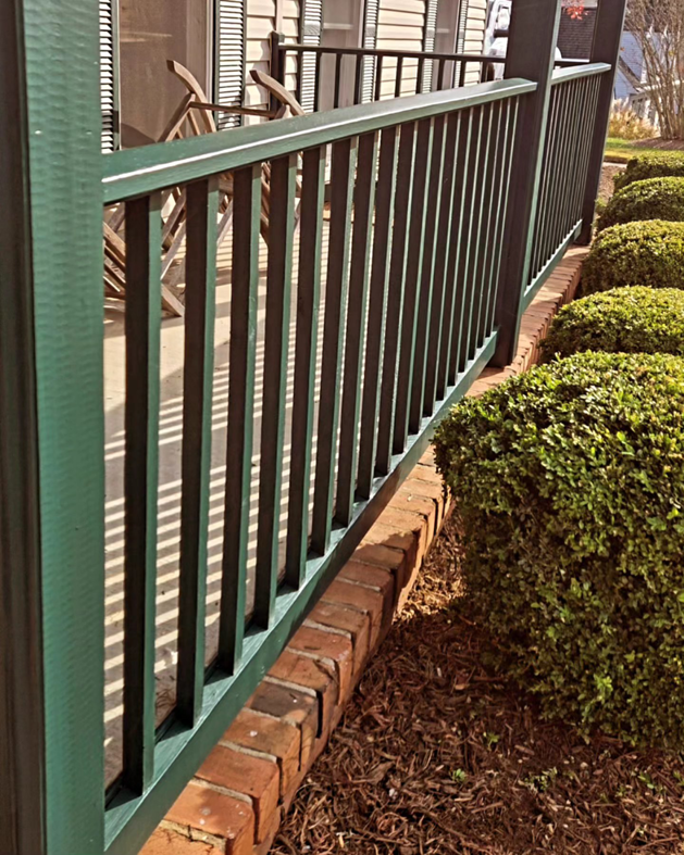 A newly painted green porch railing, showcasing quality work by DEMIA 17 & Company LLC in Waldorf, MD.