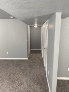 A newly painted room with fresh grey carpet and white trim by Advanced Remodeling Services in Elbert, CO.