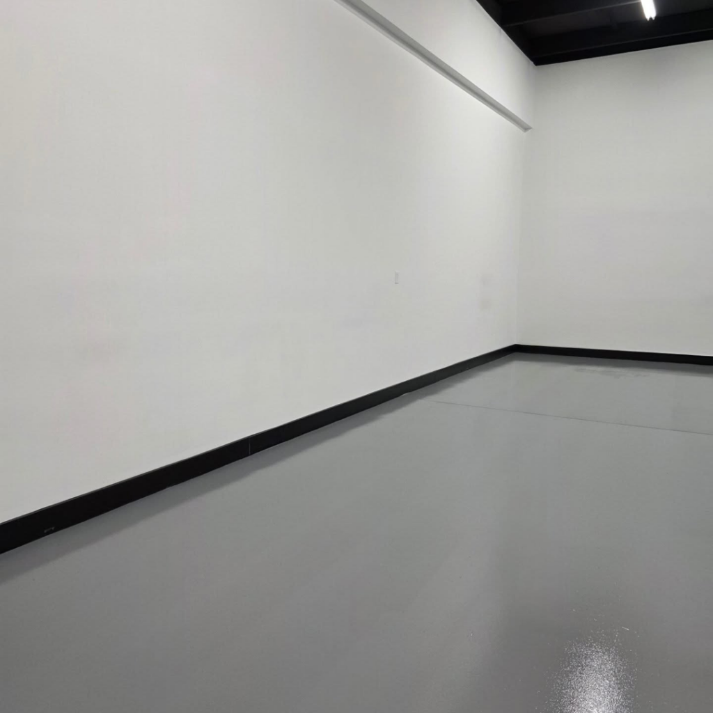 A newly painted room with crisp white walls and a clean grey floor by Painting Pros of Knoxville in Knoxville, TN.