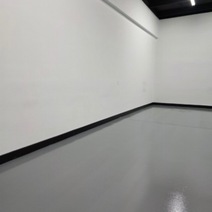 A newly painted room with crisp white walls and a clean grey floor by Painting Pros of Knoxville in Knoxville, TN.