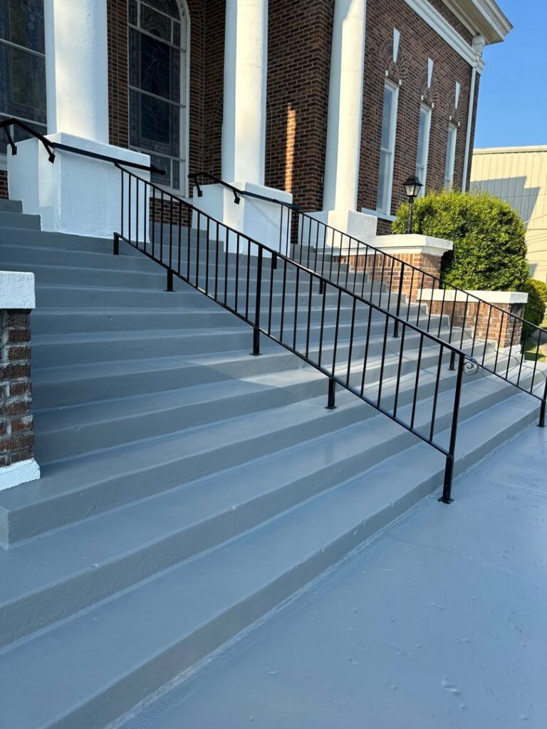 Newly painted gray concrete steps with new black metal railings, completed by Northcross Restoration Inc in Memphis, TN.
